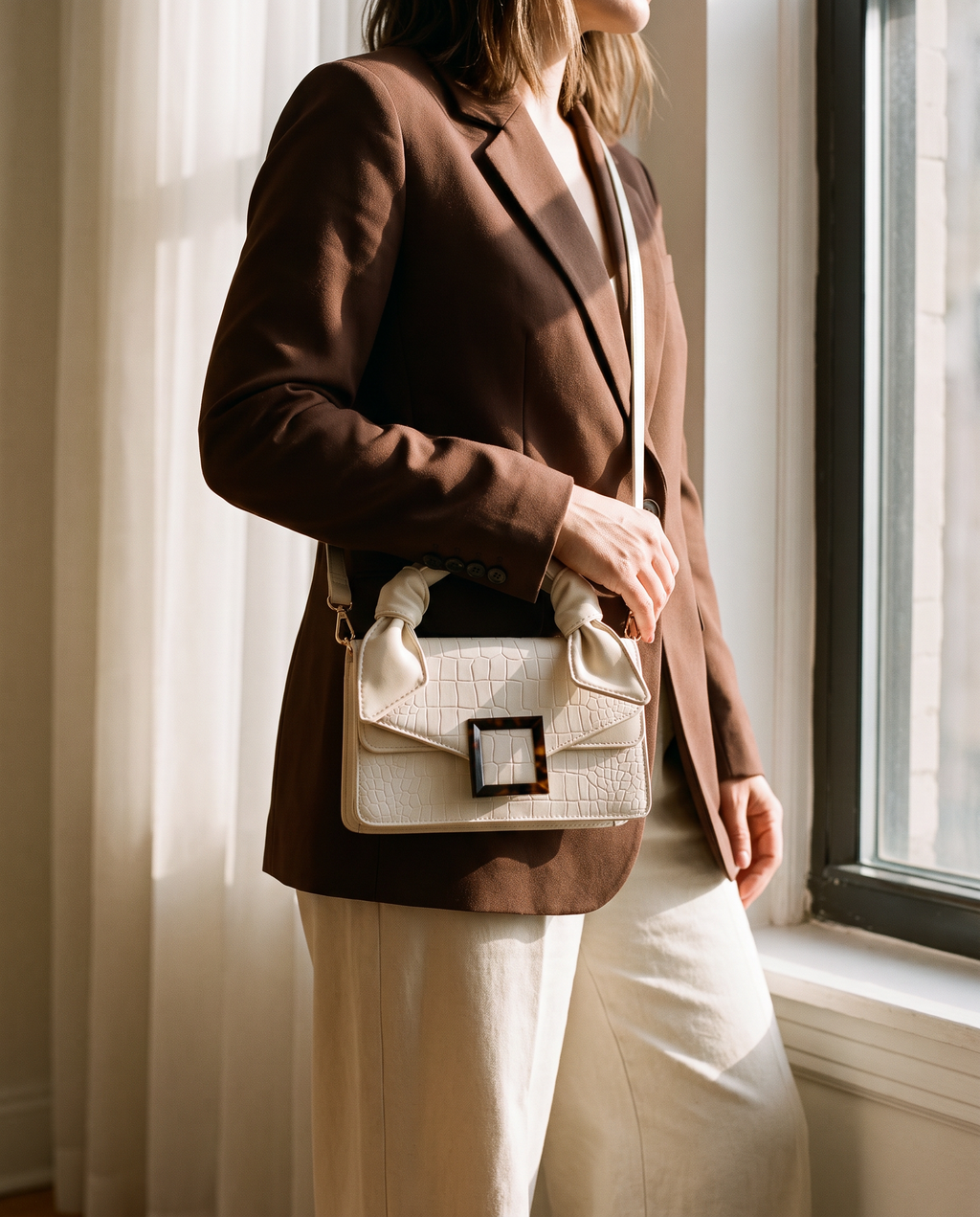Mujer con el bolso bandolera Amélie marfil y blazer chocolate