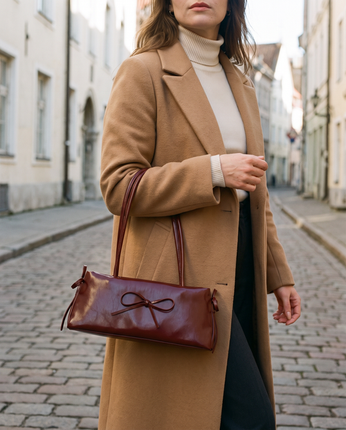 Mujer con el bolso baguette Luna burdeos y abrigo camel