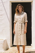 Woman wearing the Vera oat linen-blend shirt dress belted at the waist in Mediterranean daylight