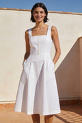 Woman wearing the Marta white cotton poplin sleeveless midi dress with a square neckline on a sunlit terrace